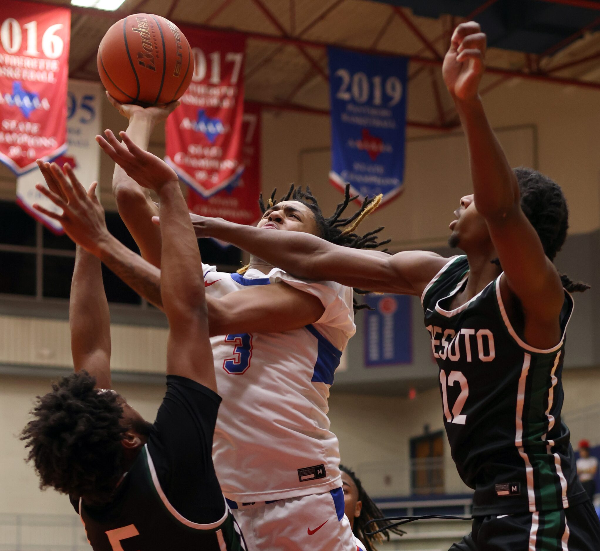 Duncanville guard Brandon Davis (3) drives hard to the basket as he shoots against DeSoto...