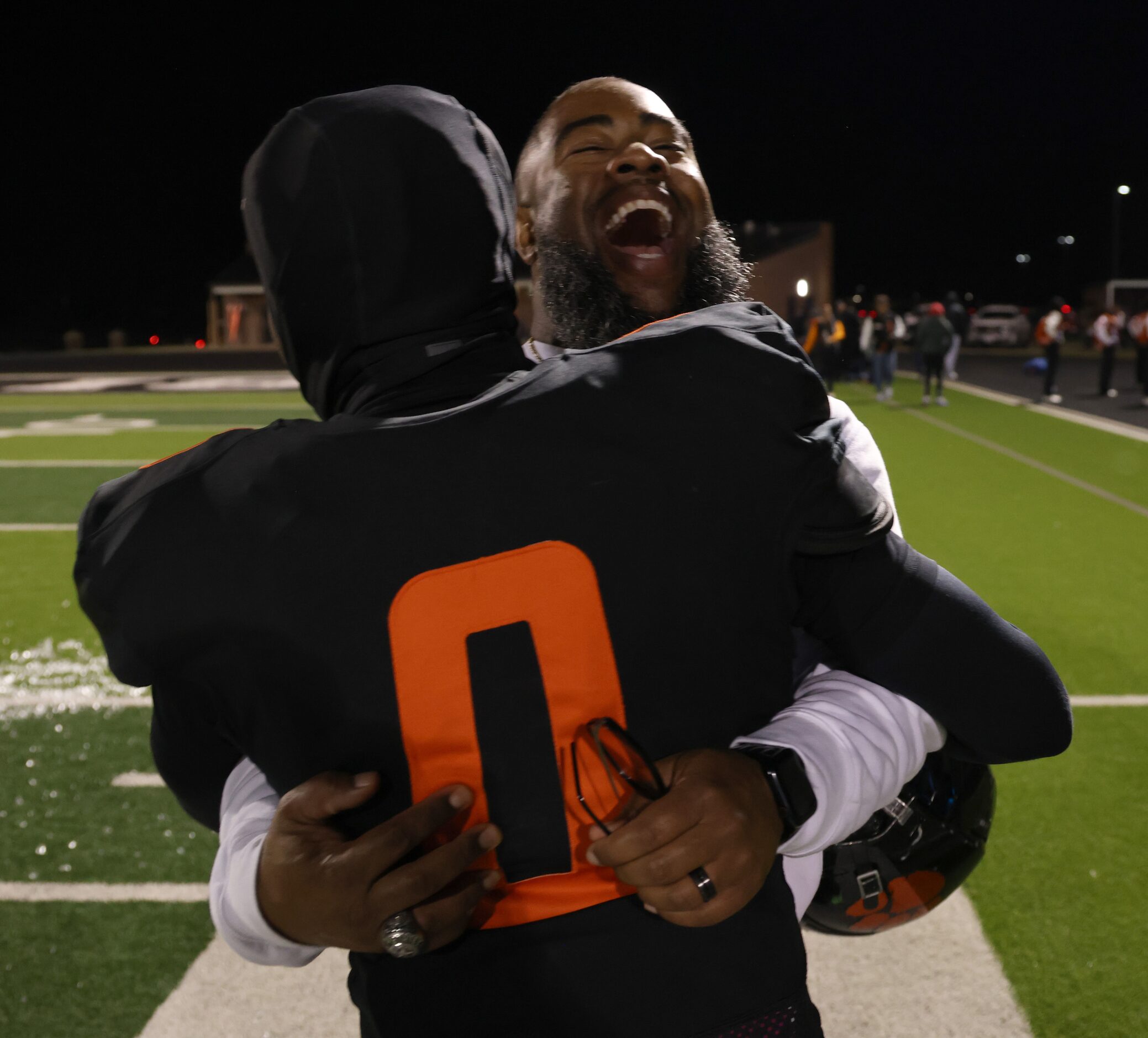 Lancaster head coach Leon Paul beams as he shares a hug with receiver Ti'Erick Martin (0)...