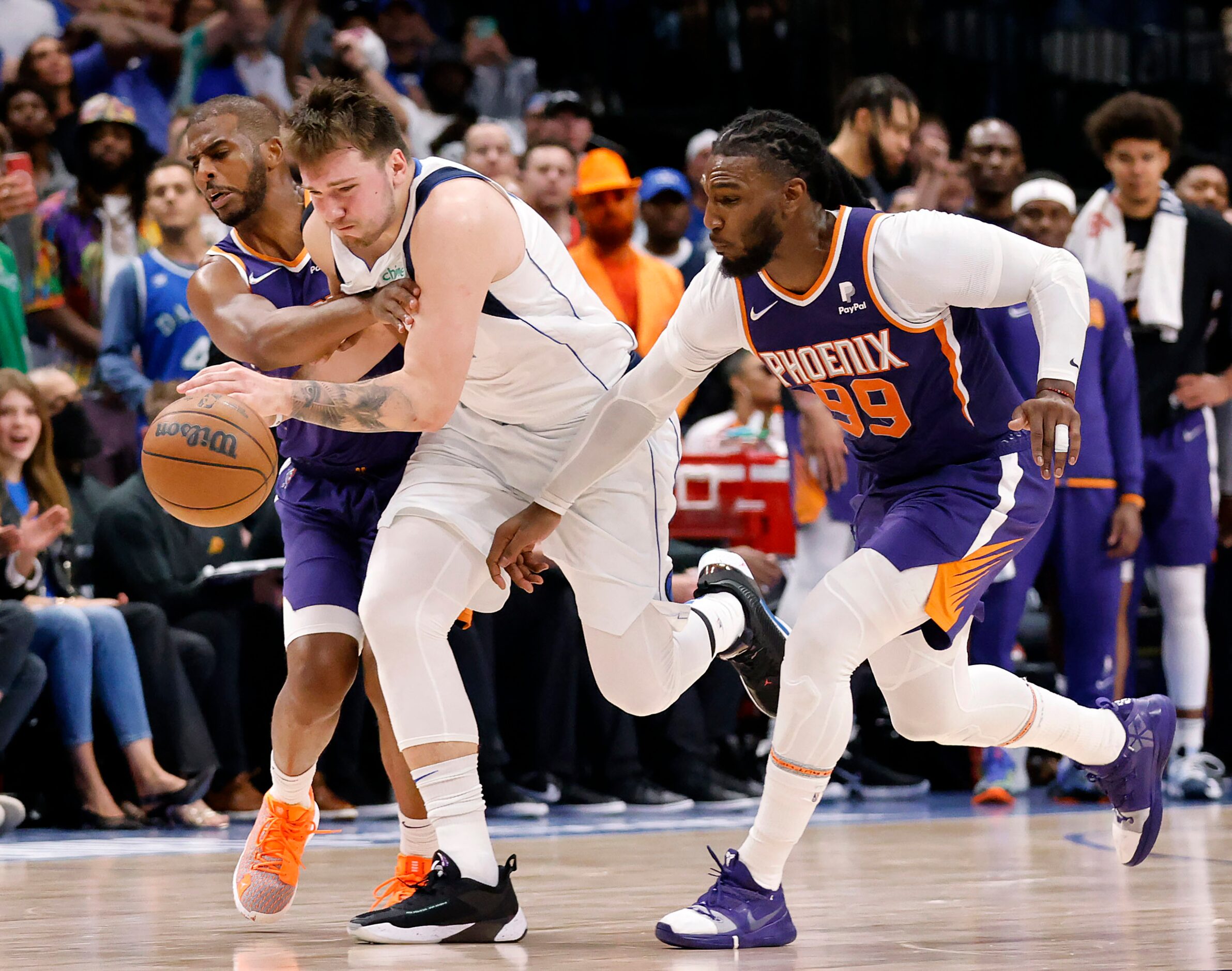 Dallas Mavericks guard Luka Doncic (77) is fouled as he is double teamed by Phoenix Suns...