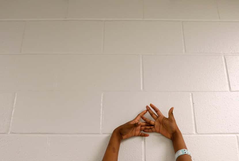 
A girl inmate places her hands against the wall for a routine search that follows breakfast...