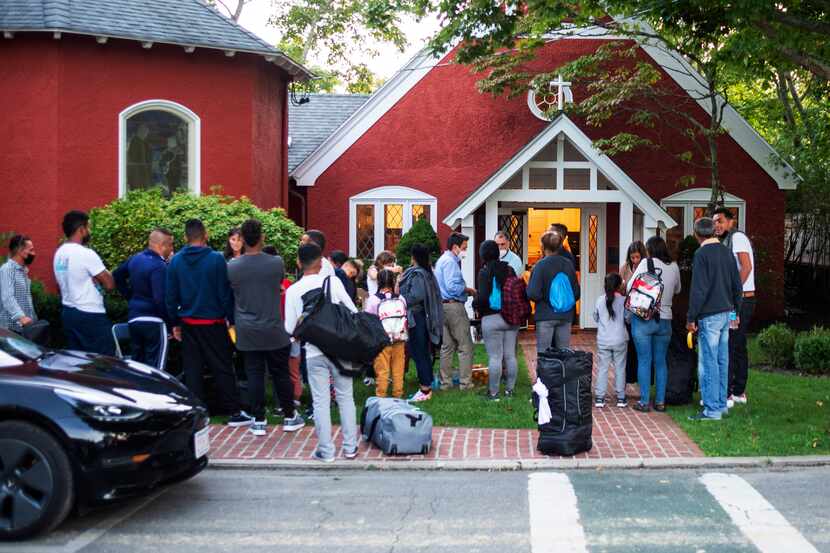 Immigrants gather with their belongings outside St. Andrews Episcopal Church, Wednesday...