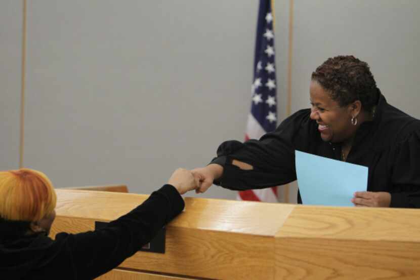Judge Lela Mays gives a congratulatory fist bump to a member of the S.T.A.C. (Successful...
