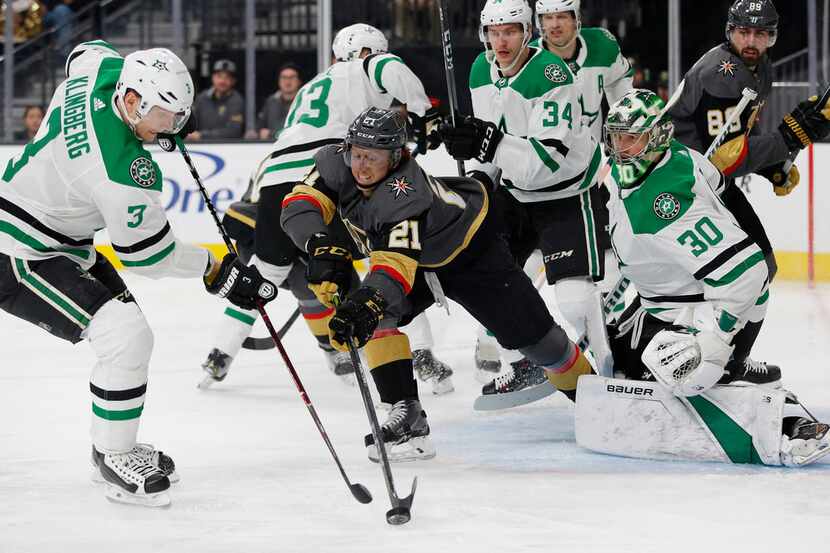 Vegas Golden Knights center Cody Eakin (21) reaches for the puck in front of Dallas Stars...