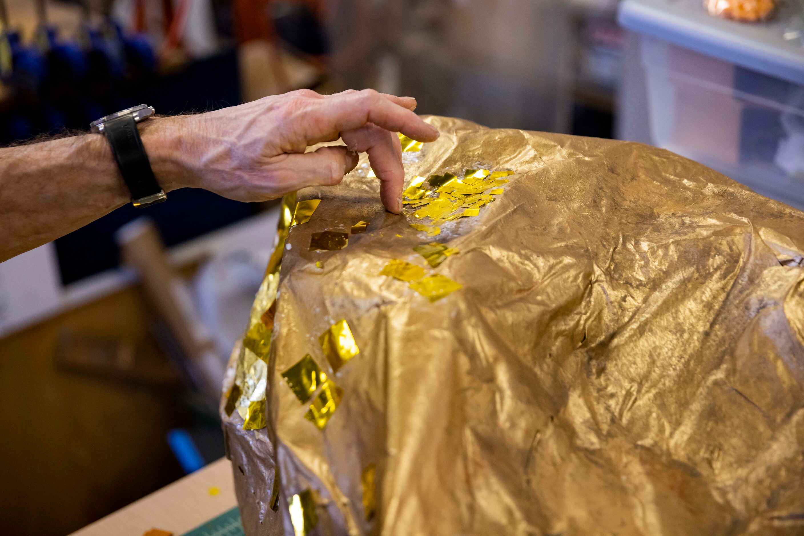 Prop designer Tommy Bourgeois adds shimmer to a gold nugget prop for Dallas Opera’s Das...