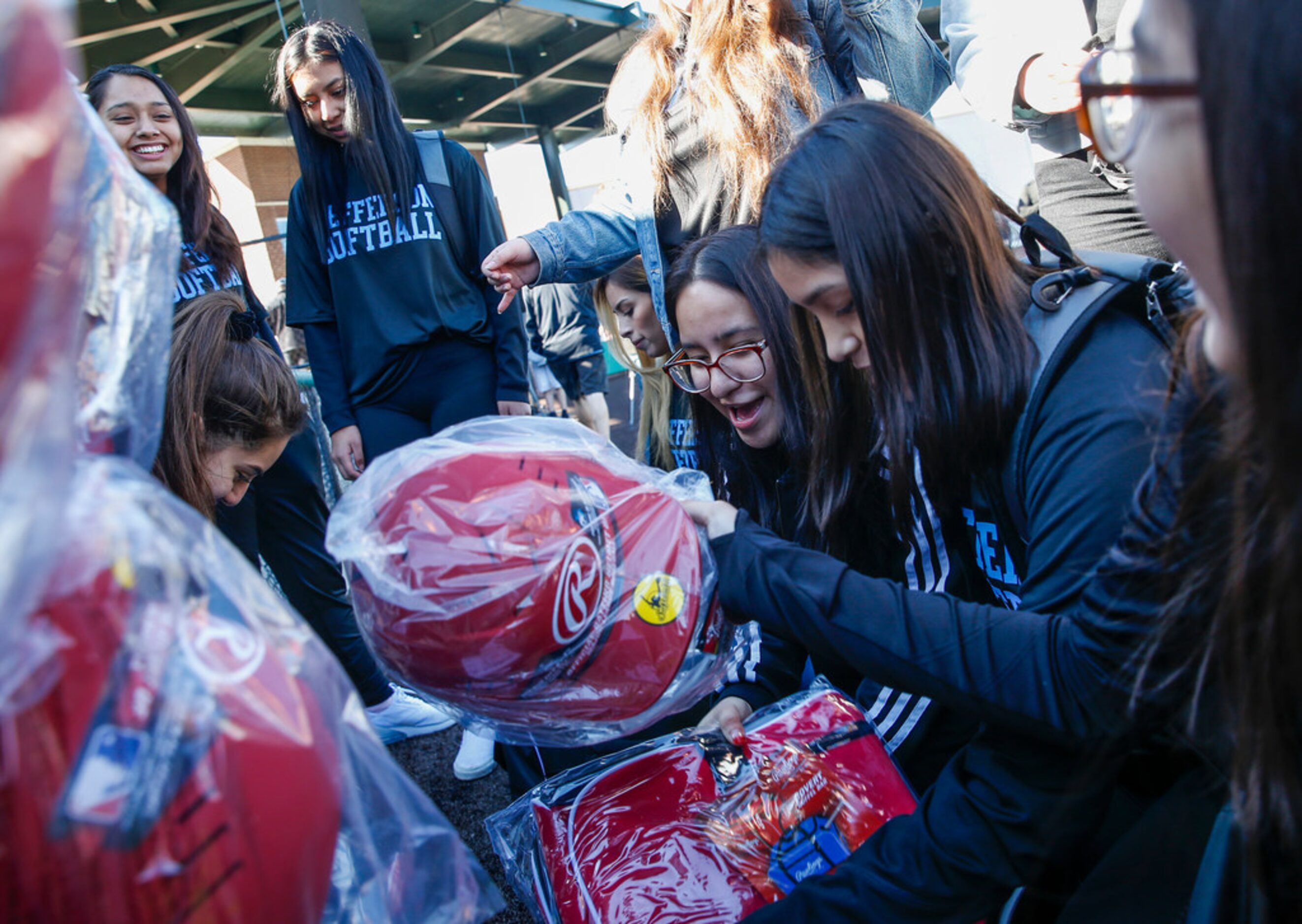 Thomas Jefferson High School softball players react after receiving a donation from Rangers...