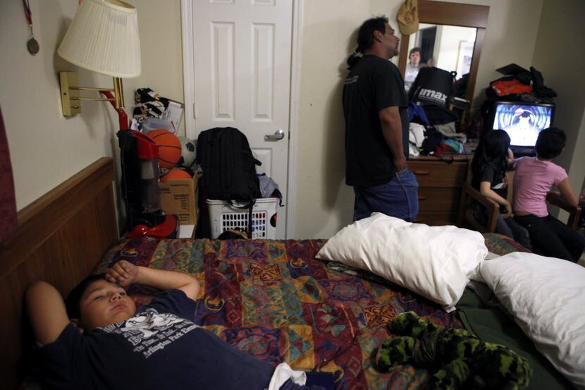 Nick Lara, 11, lays on his bed while Skylar French (second from right), 7, and a friend...