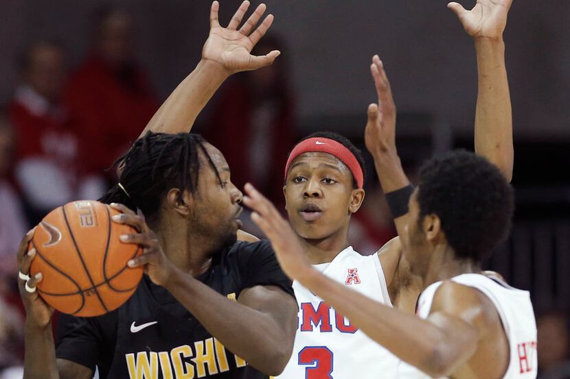Wichita State forward Zach Brown (1) looks for room against SMU guards William Douglas (3)...