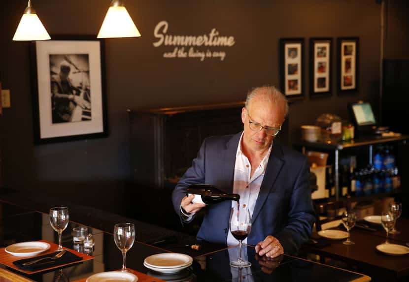 Urbano Cafe owner Mitch Kauffman pours wine in the restaurant's dining room on Fitzhugh Avenue.
