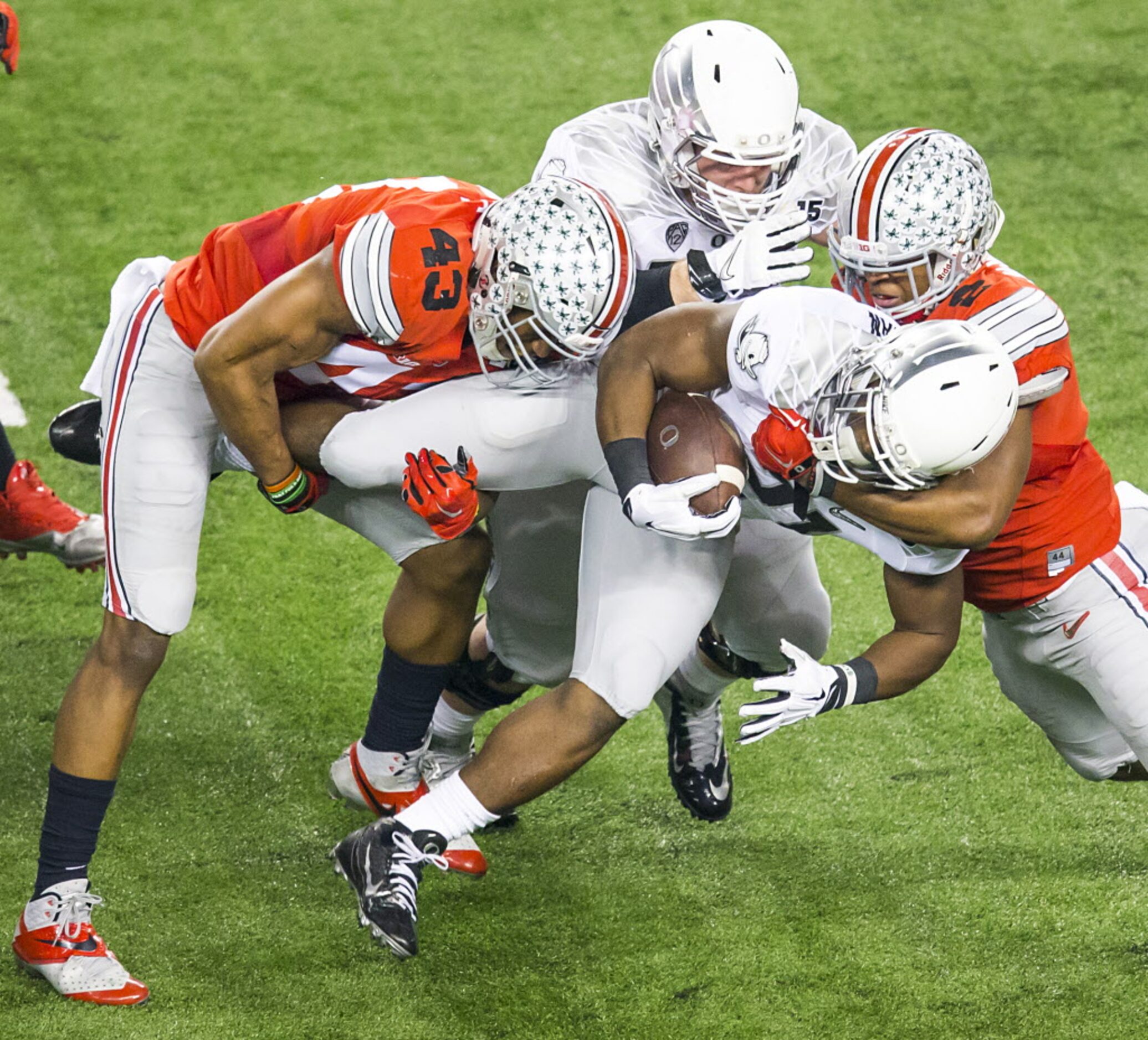 Oregon Ducks running back Royce Freeman (21) is tied up by the Ohio State Buckeyes defense...