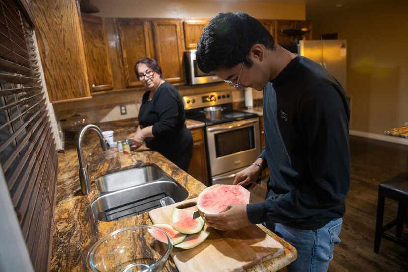 Duncanville High School student David Mojica, 15, cuts watermelon at his home in Dallas....