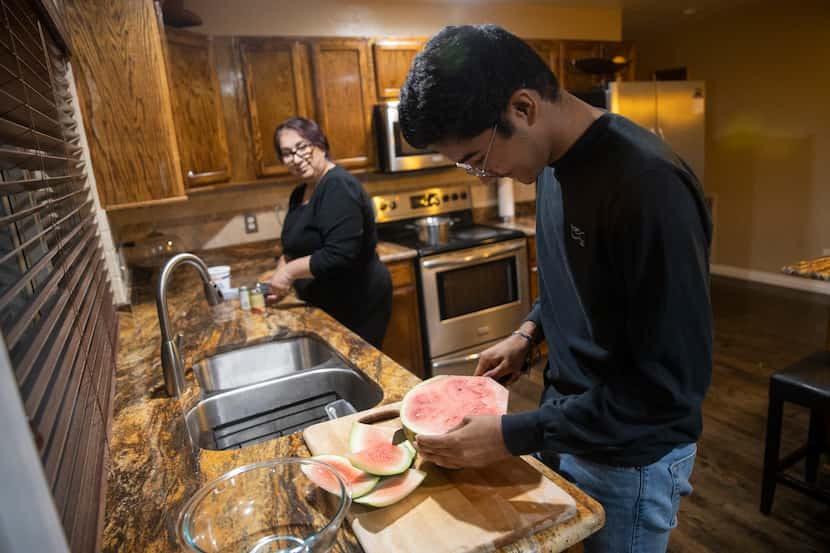 Duncanville High School student David Mojica, 15, cuts watermelon at his home in Dallas....