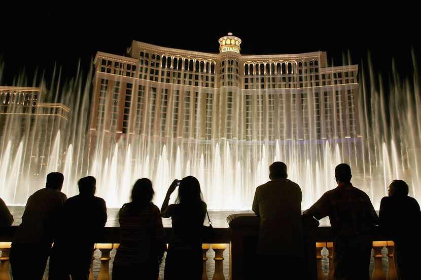Tourists are silhouetted as they watch the Bellagio fountain show on the Las Vegas Strip in...
