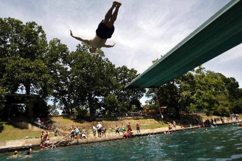 Todd Mouser of Los Angeles dives at Barton Springs Pool during a free swim day.
