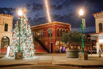 A lighted Christmas tree towering over a town square