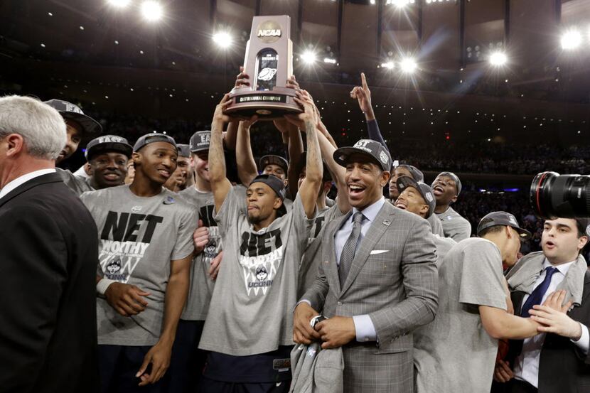Connecticut head coach Kevin Ollie, center right, celebrates with his team after beating...