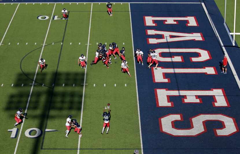 The Allen High football team runs a pass play during spring football practice at Eagle...