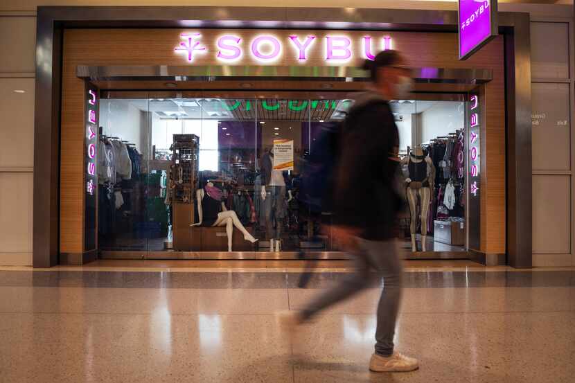 Travelers walk in front of the closed store front of Soybu clothing store inside Terminal B...