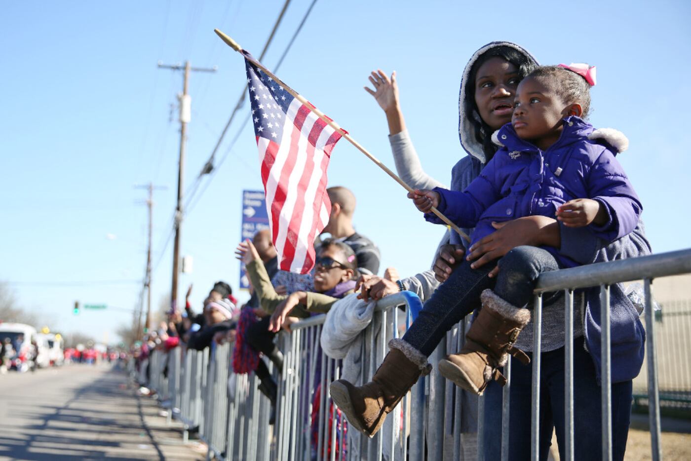 Kasonia Harris holds her daughter Anyra Harris, 2, as she waves the flag of the United...