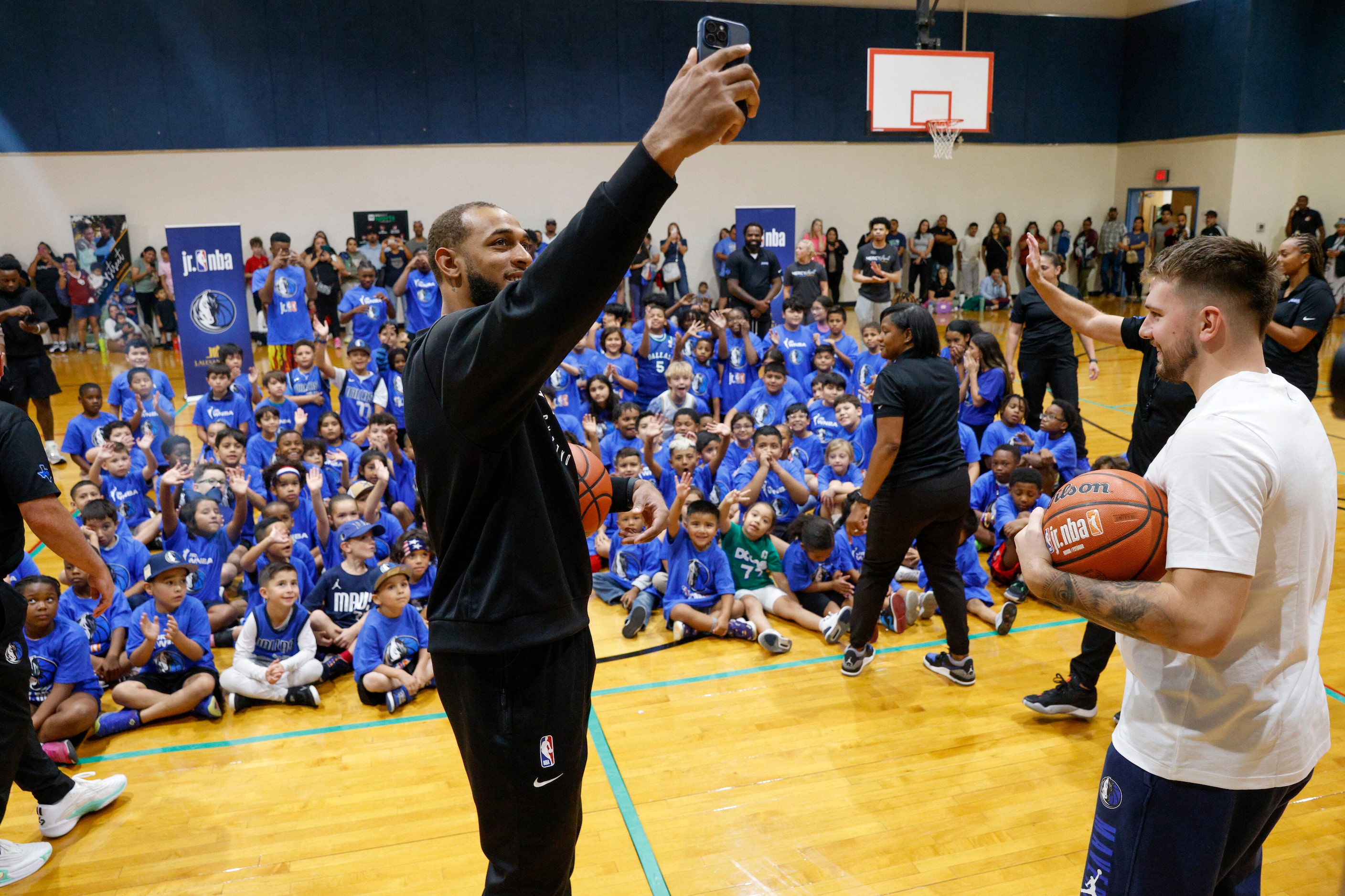 Dallas Mavericks center Daniel Gafford takes a selfie after a children’s basketball clinic,...