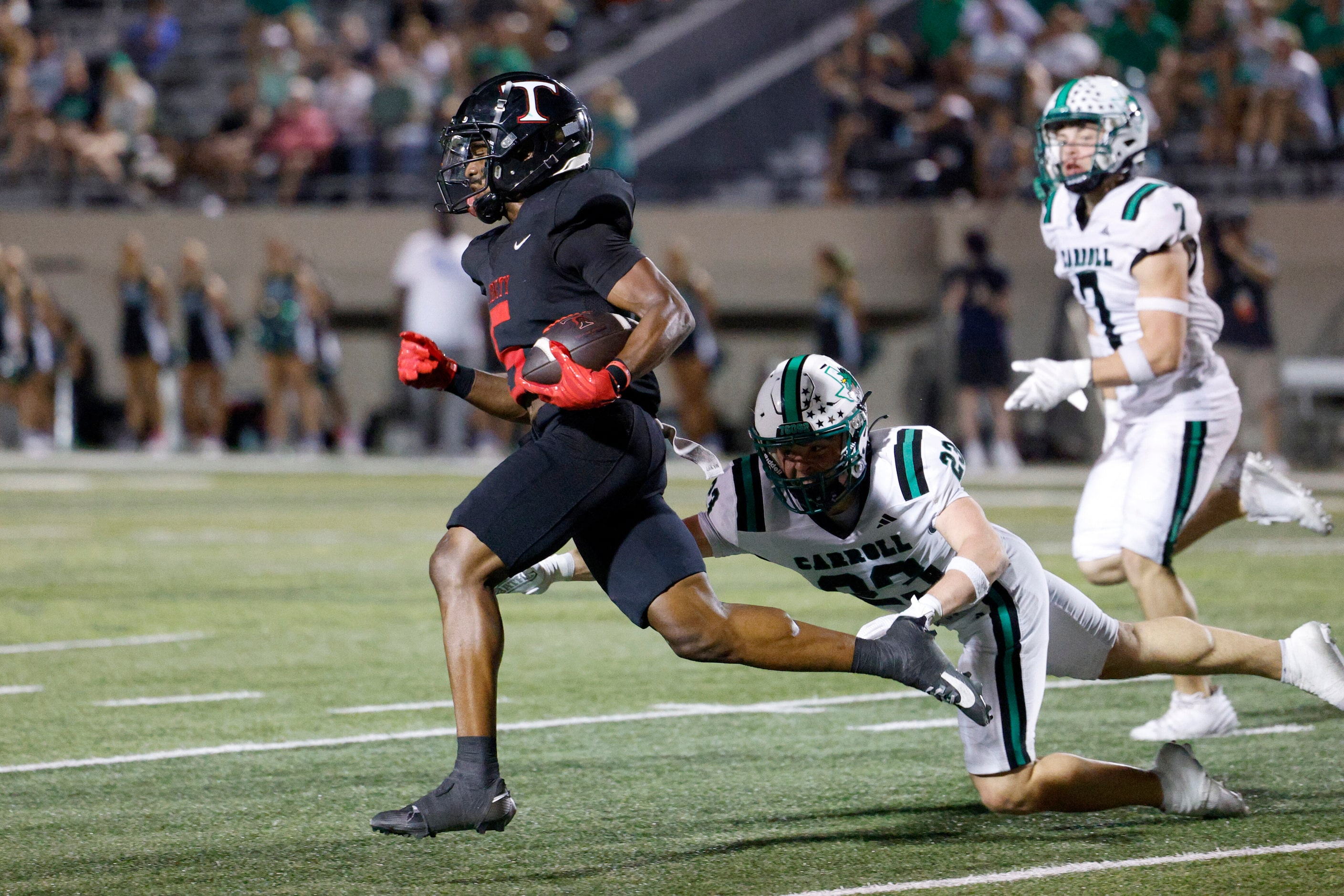 Southlake Carroll defensive back Austin Bussmann (23) dives trying to tackle Euless Trinity...