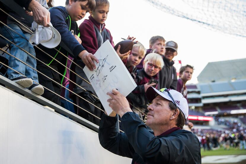 Texas A&M head coach Jimbo Fisher signs autographs after the Aggies' Maroon and White game...