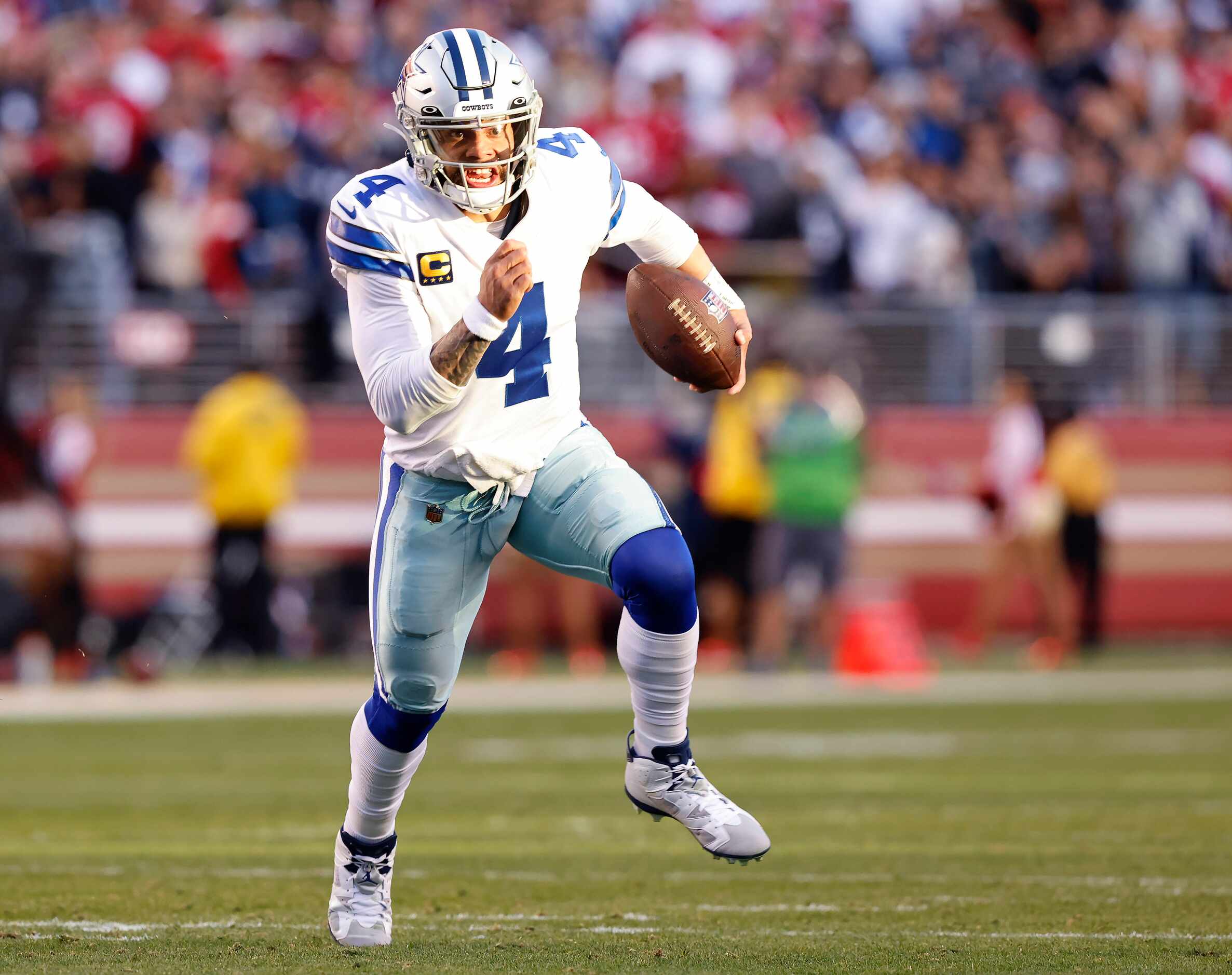 Dallas Cowboys quarterback Dak Prescott (4) looks to the end zone as he keeps the ball and...