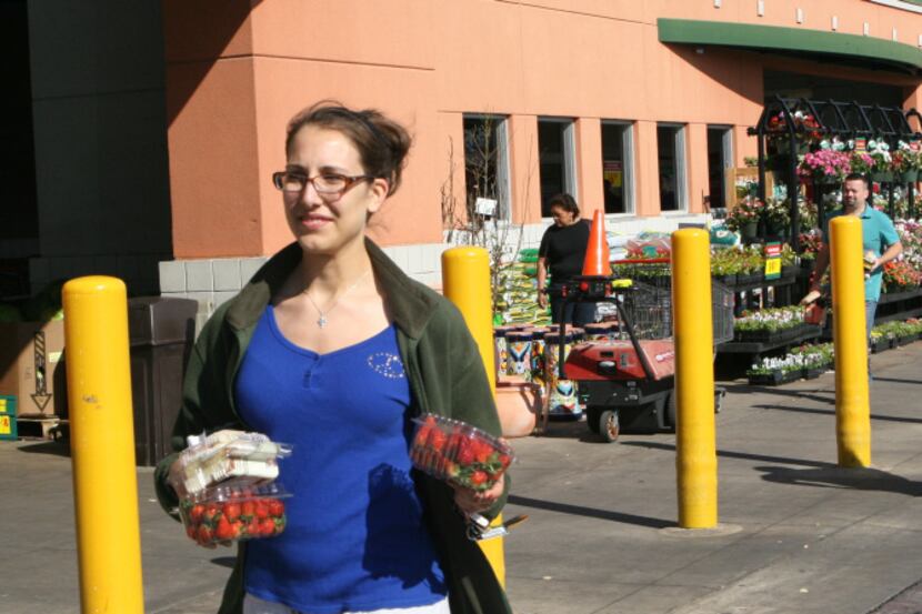 Kellie Fineman, a University of Texas senior, carries her purchases in her hands after...