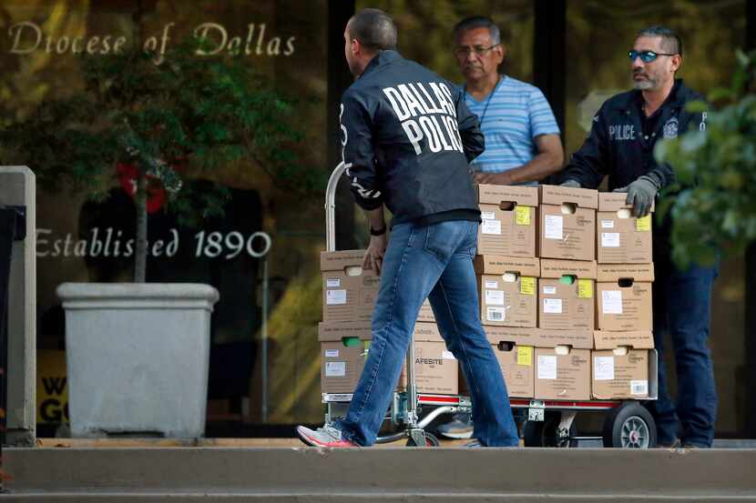 Dallas police officials carted out boxes during a raid on the Catholic Diocese of Dallas on...