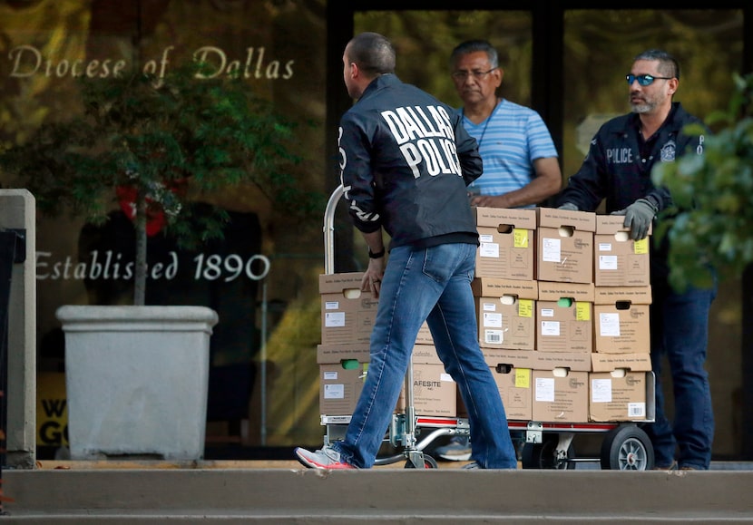 Dallas police officials carted out boxes during a raid on the Catholic Diocese of Dallas on...