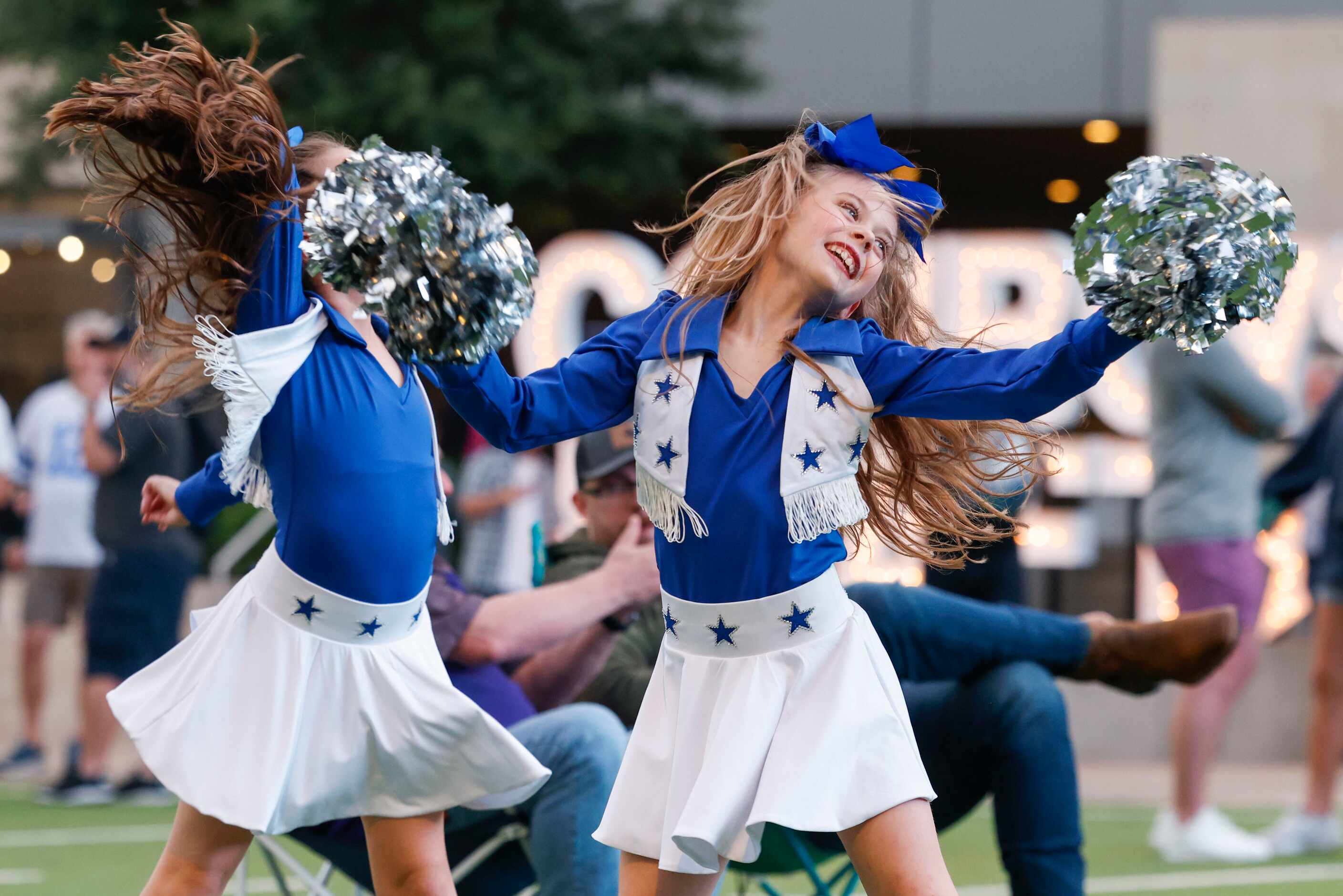 Amelia Purdue, 9, (left) with her friend Hannah Paulek, 9,  dance to a song during an NFL...