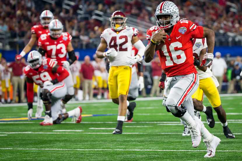 Ohio State quarterback J.T. Barrett (16) gets past the USC defense on a 28-yard touchdown...