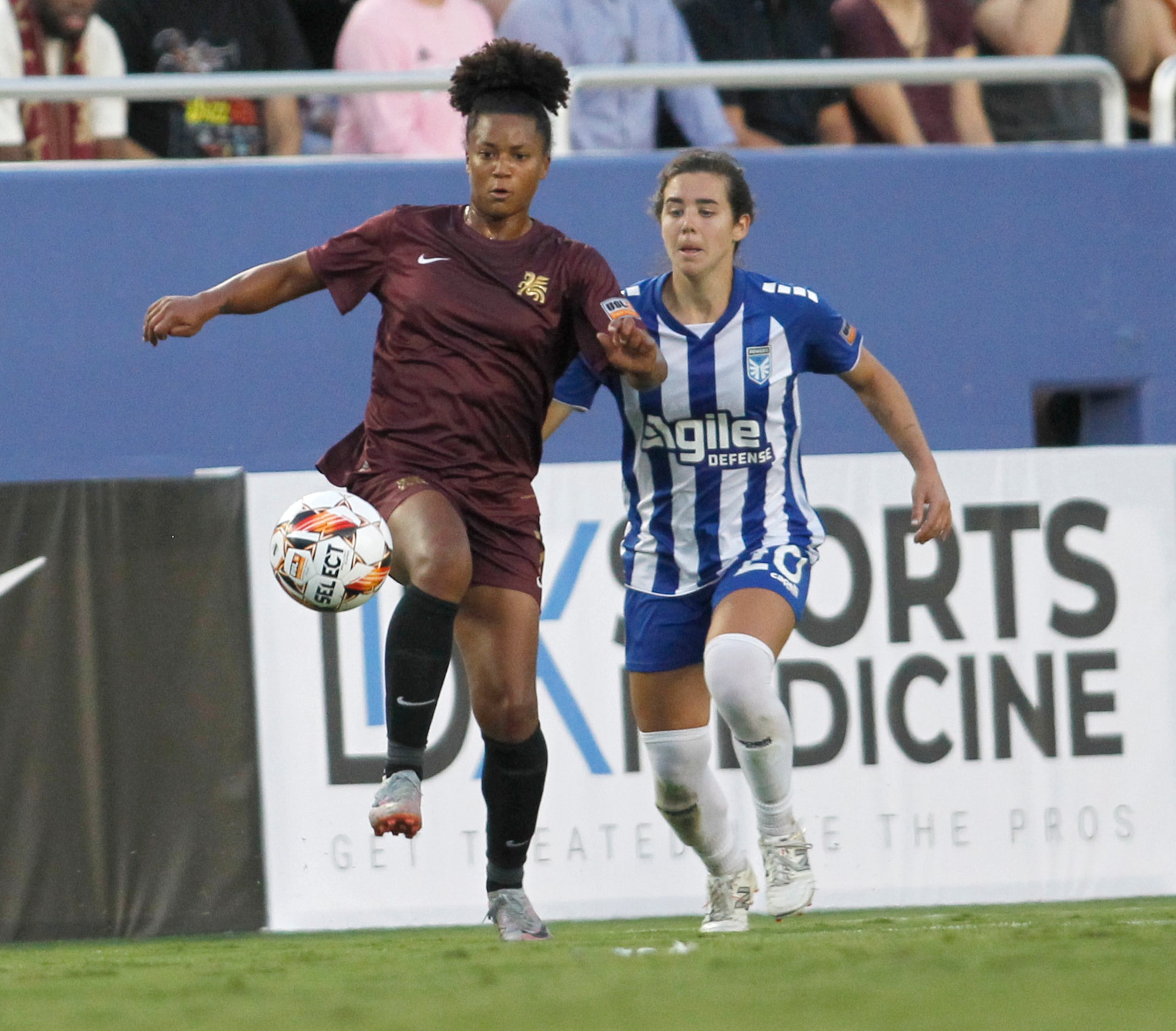 Dallas Trinity FC's Enzi Broussard (7), left, controls the ball as DC Power FC's Anna Bagley...