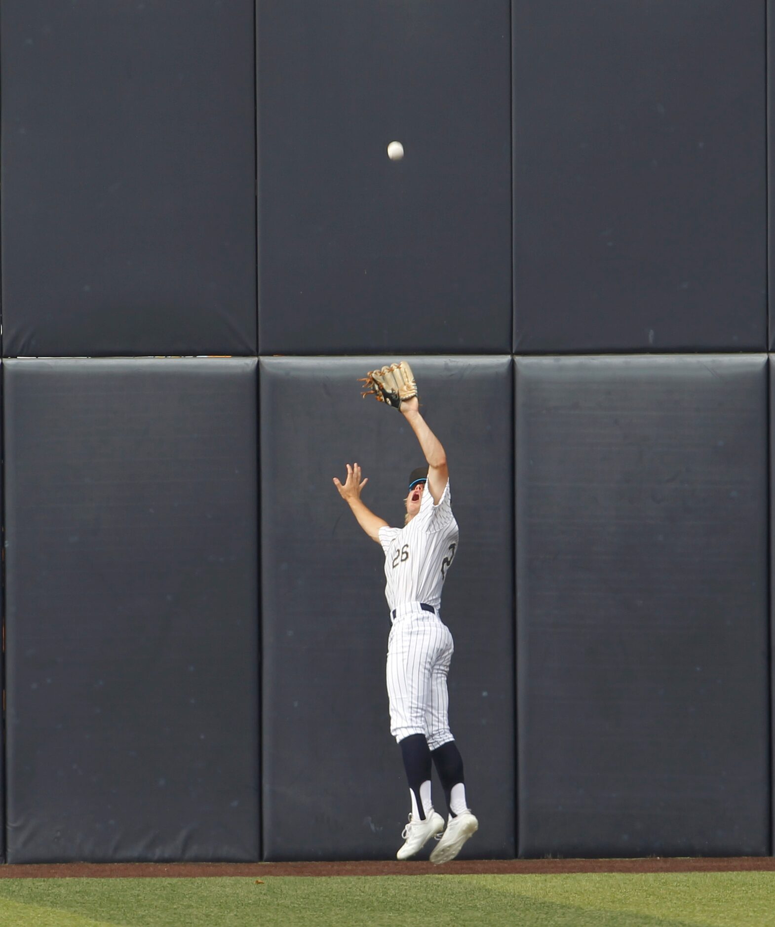 Keller center fielder Brock Burkett (26) leaps to catch a long drive to the wall to retire a...