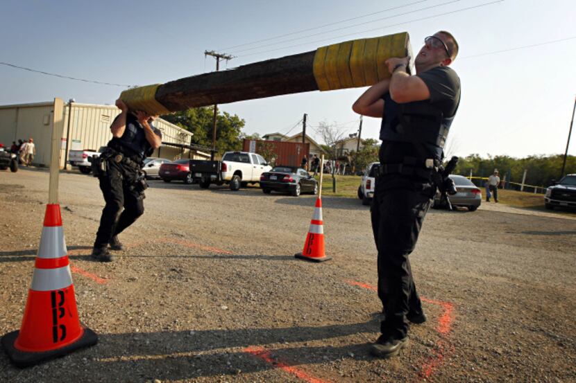 David Martin (right) and Charles Crawford of the Arlington Police SWAT team lift a railroad...