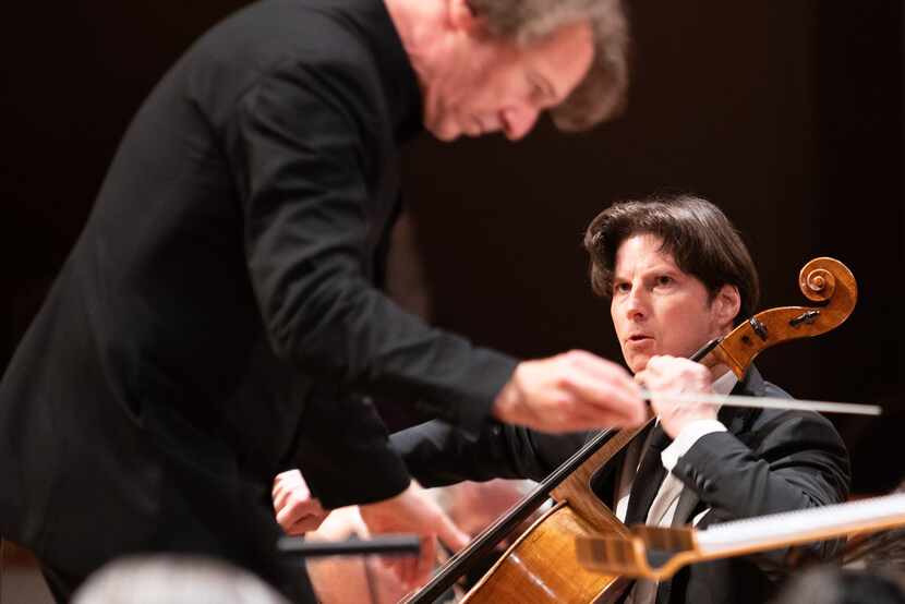Cellist Daniel Müller-Schott (center) looks at guest conductor Marc Albrecht as they perform...