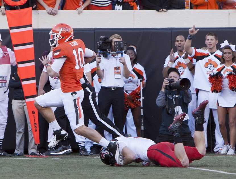 Nov 17, 2012; Stillwater OK, USA; Oklahoma State Cowboys quarterback Clint Chelf (10) runs...