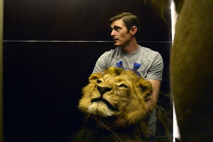Brandon Casteel carrying the head of a lion at the Dallas Safari Club Expo in Dallas.