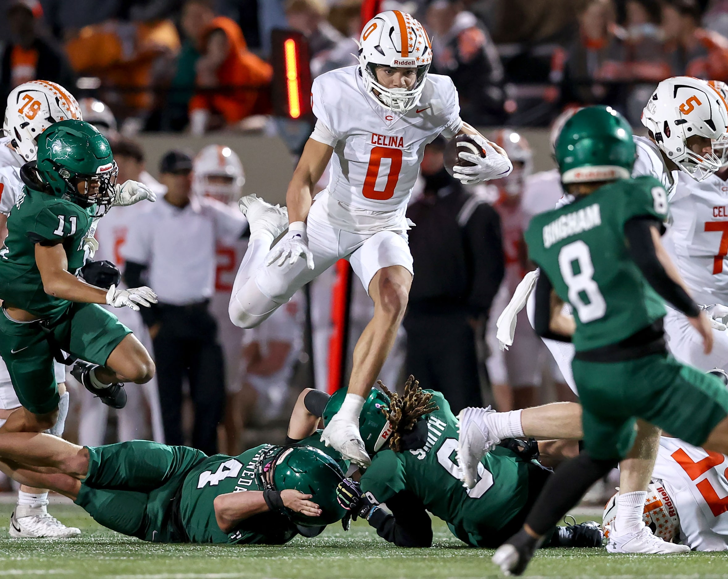 Celina wide receiver Ethan Rucker (0) leaps over Kennedale cornerback Tyler Greenfield (4)...