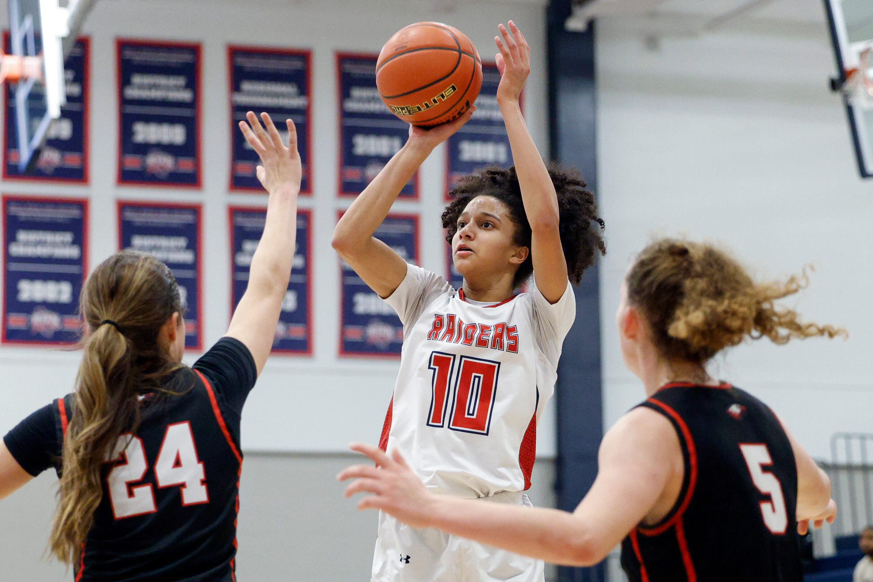 Denton Ryan forward Kinley Lewis (10) shoots over Argyle guard Brooklyn Northeim (24) and...