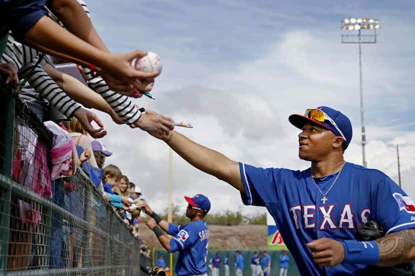 Texas outfielder Michael Choice sign autographs for fans during the Texas Rangers vs. the...