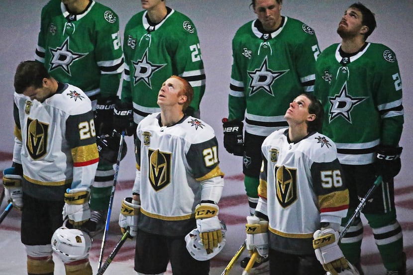 The Dallas Stars team takes up a position behind the Vegas Golden Knights team as a show of...