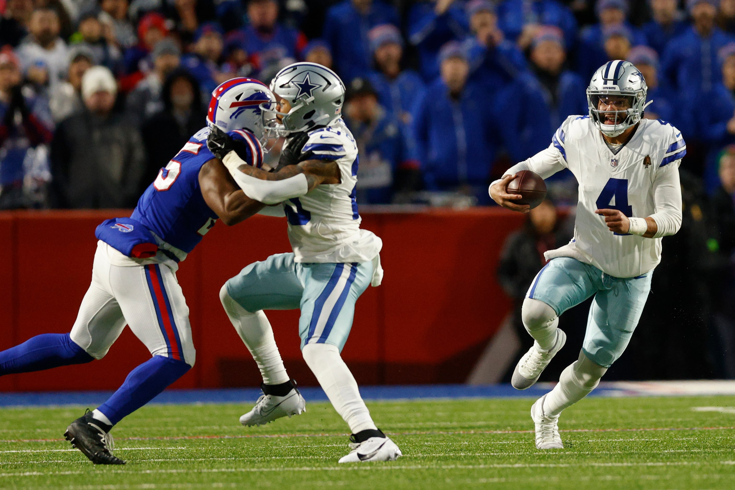 Dallas Cowboys quarterback Dak Prescott (4) runs the ball as running back Tony Pollard (20)...