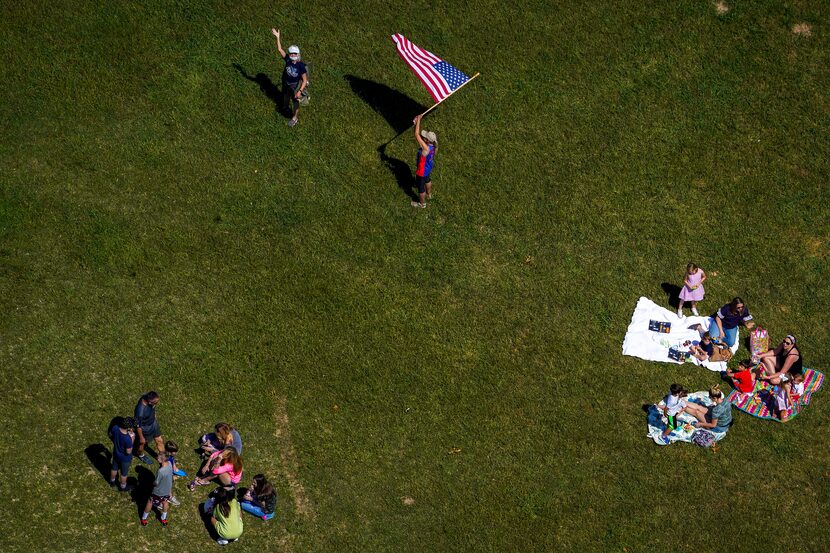 People gathered at Winfrey Point at White Rock Lake after the Navy's Blue Angels flew over...