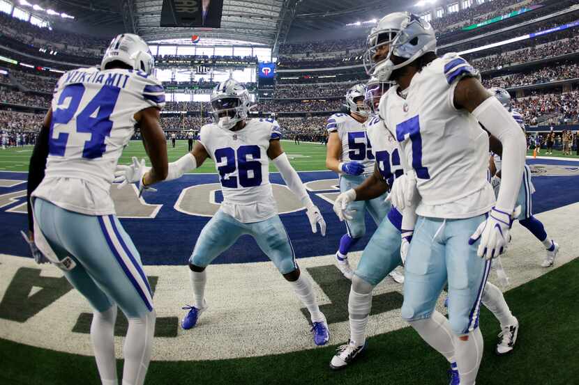 Dallas Cowboys' Israel Mukuamu (24), Trevon Diggs (7) and others celebrate with cornerback...