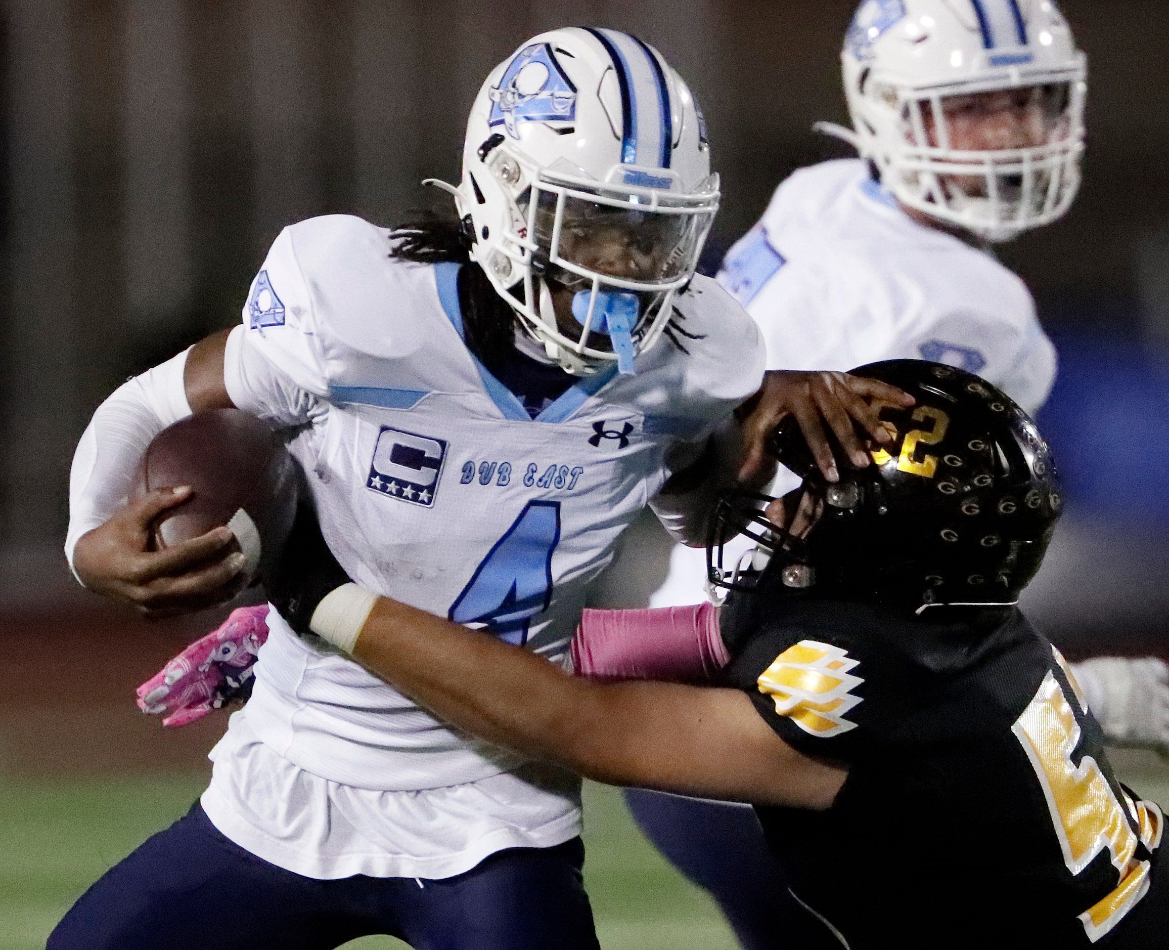 Wylie East High School quarterback Howard Fisher IV (4) tries to escape the grasp of Garland...