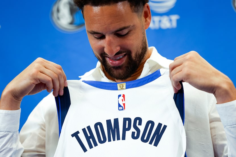 Klay Thompson poses with his jersey following a NBA news conference where he was introduced...