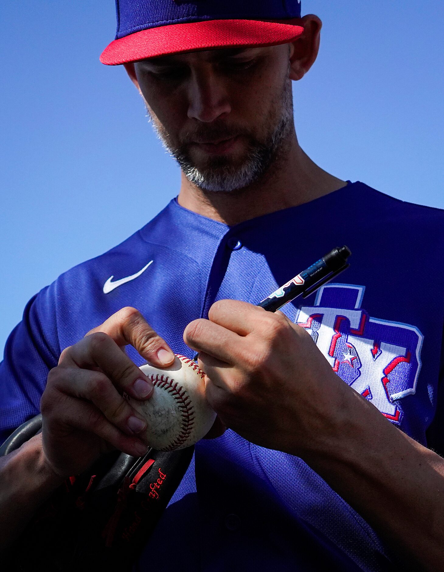 Texas Rangers pitcher Mike Minor signs autographs following a spring training workout at the...