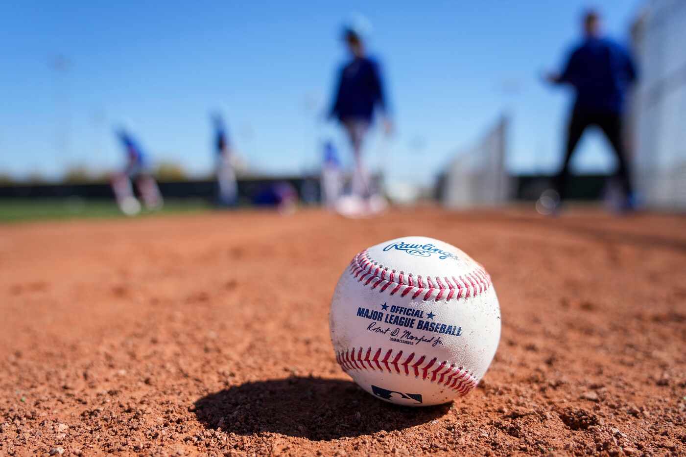 A baseball rests on the warning track as Texas Rangers warm up before a bullpen session...