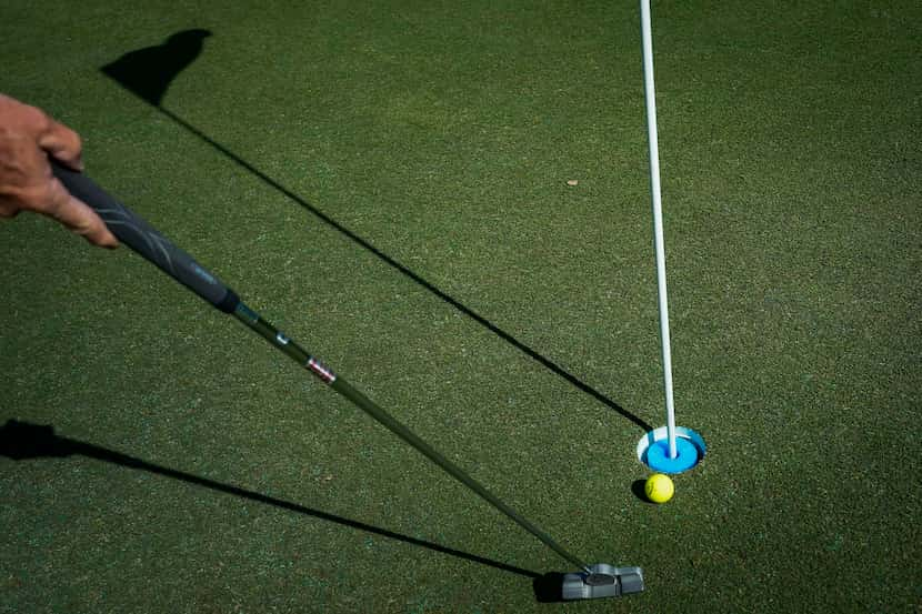 A golfer taps in a put on the first green at Golf Club of Dallas on Wednesday, April 1,...