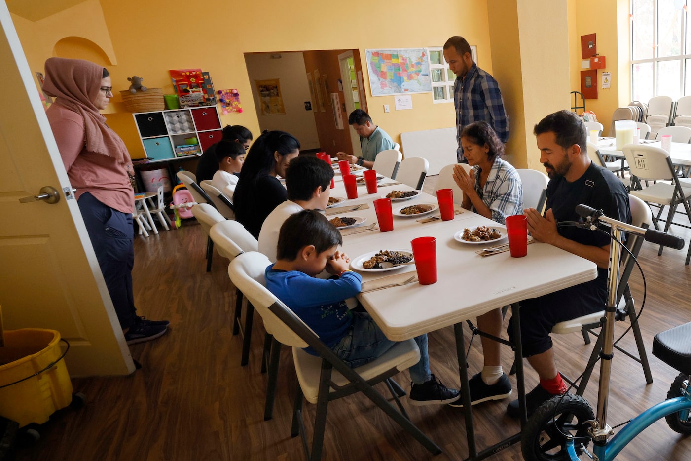 Gabriel Ribeiro (right), a migrant from Espírito Santo, Brazil, prays with other migrants...